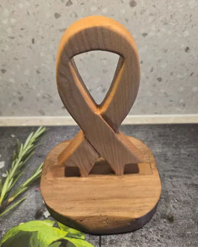 Dos du trophée Octobre rose : nœud en frêne emboîté dans le socle en noyer